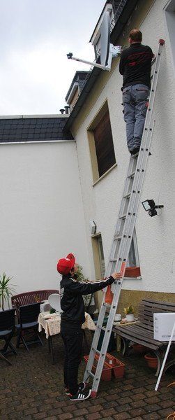 Monteur bei der Montage einer Satellitenanlage
